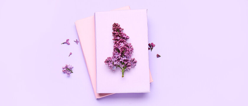 Lilac flowers and books on purple background