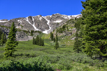 Nature undisturbed during a remote hiking to Lost Lake, Colorado. Clear, blue skies are prevalent with some snow atop the higher elevations. 