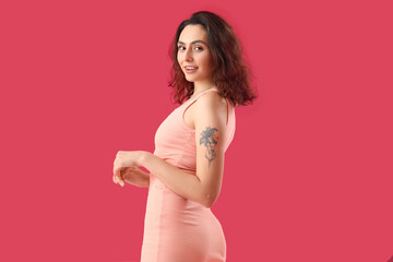 Naklejka na ściany i meble Attractive young woman in dress on pink background