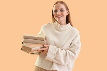 Young woman with books on beige background