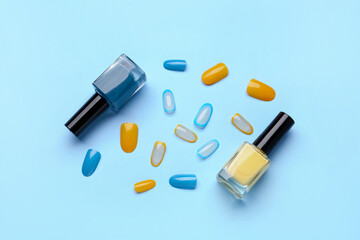 Press-on nails with polishes on blue background