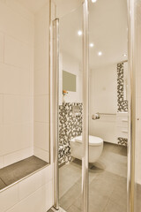 a modern bathroom with black and white tiles on the walls, floor, and shower stall in front of the...