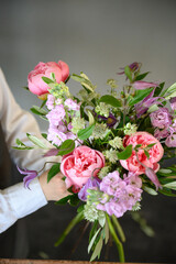 Lush bouquet of flowers in hands of arranger