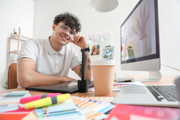 Obraz premium Male graphic designer working at table in office