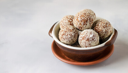 energy balls in a ceramic bowl on a light background, copyspace