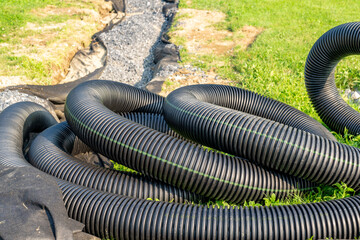 Black storm water underdrain pipe used to mitigation ground water.  Abstract rounded shape.