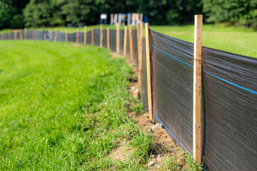 Silt Fence fabric with wooden posts installed prior to the start of construction.
 - Powered by Adobe