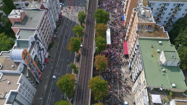 train on elevated railroad, Stunning aerial top view flight 
CSD Pride Love Parade 2023 in city Berlin Germany Summer day. tilt up drone
4K Cinematic footage.