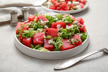 Plate of tasty watermelon salad on light background