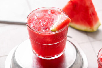 Glass of tasty watermelon fresh on white tile background