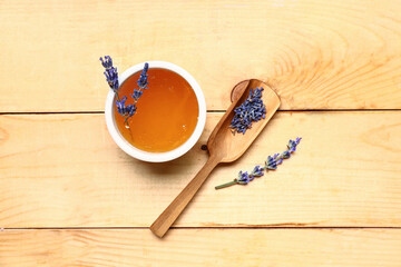 Bowl of sweet lavender honey on wooden background