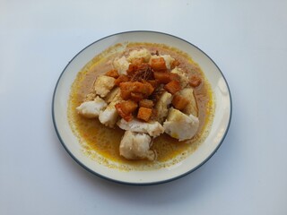 dish of vegetable ketupat (ketupat lontong sayur) with coconut milk sauce on a plate top view against a white background. healthy food background concept, food recipe, homemade food, breakfast, lunch