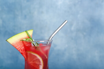 Glass of tasty watermelon cocktail on grunge blue background