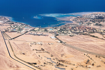 Aerial View of the Red Sea Coast in Hurghada, Egypt with many hotels bay out of airplane landing - 627948802