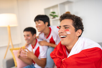 Three friends cheering for their team watching a soccer game