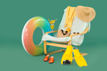 Deckchair, beach accessories, photo camera and glass of cocktail on color background