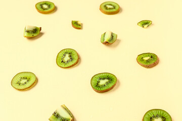 Slices of fresh kiwi on yellow background