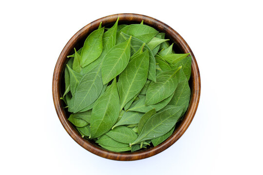 Henna or Lawsonia inermis leaves in a wooden bowl on white background 