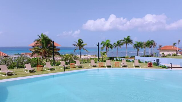 Aerial flyback over pool  and deckchairs of Hilton Garden Inn Hotel at La Romana in Dominican Republic