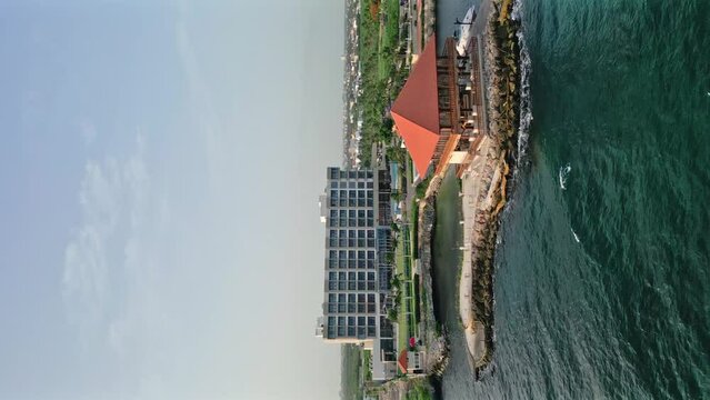 Vertical format of Hotel Hilton Garden Inn of La Romana in Dominican Republic seen from ocean. Aerial drone view