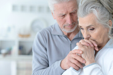 Close up portrait of sad senior couple isolated on white background