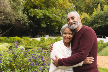 Portrait of happy senior biracial couple embracing in garden at home, copy space