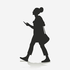 Silhouette of a woman walking while holding a cell phone