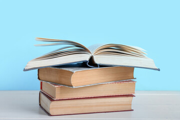 Stack of books on table against blue background