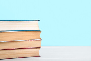 Stack of books on table against blue background