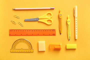 Different school stationery on orange background