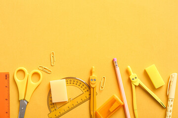 Different school stationery on orange background