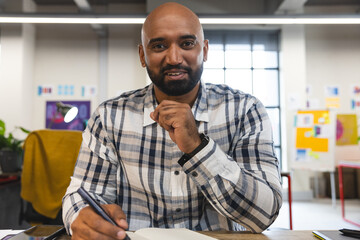 Happy indian man talking looking at the camera during a video call at office