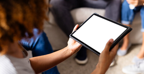 Diverse group of friends using tablet with copy space and talking in group therapy session