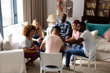 Diverse friends listening and comforting each other in group therapy session