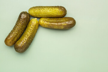 Pickled cucumbers on green background