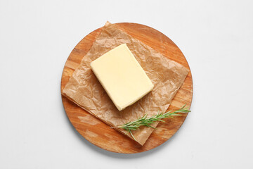 Wooden board with fresh butter and rosemary on white background
