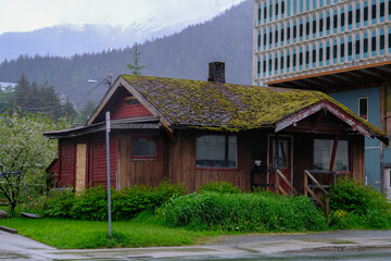 Street view cityscape town landscape nature scenery in Juneau, Alaska with historic wood house facades, gravel roads, lush vegetation, birds and private homes in old town downtown skyline	