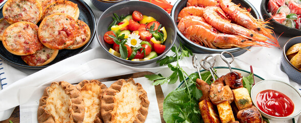 Family dinner or lunch. Many dishes on the table. Summer.