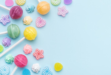 Sweet lollipops and candies on blue background