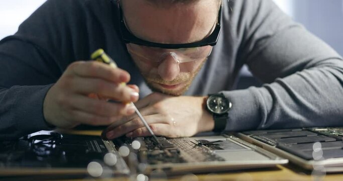 Electric maintenance, board and a man with tools for a computer service and focus on circuit. Technology, programming and a pc technician working on hardware of electronics or building a motherboard