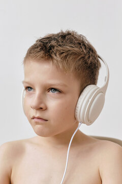 Portrait of kid listening to music in white headphones