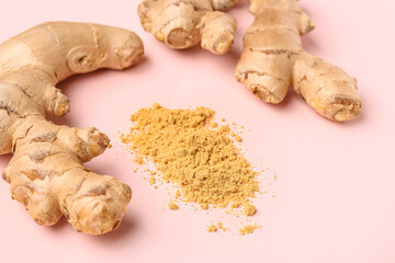 Fresh ginger roots and dried powder on pink background