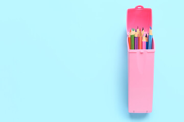 Case with colorful pencils on blue background