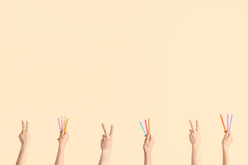 Hands with different pens on beige background