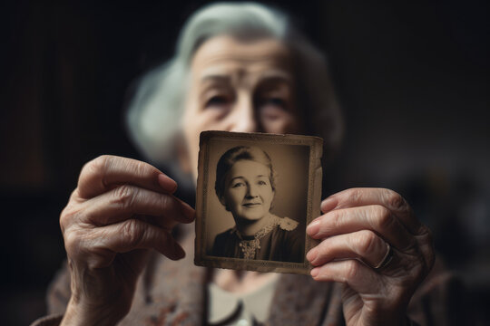 Senior white woman holding up a vintage photo of herself when she was younger, generative AI