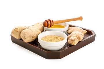 Tray with fresh ginger roots and bowl of dried powder on white background