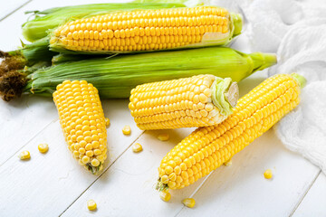 Fresh corn cobs on white table