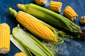 Fresh corn cobs on blue table