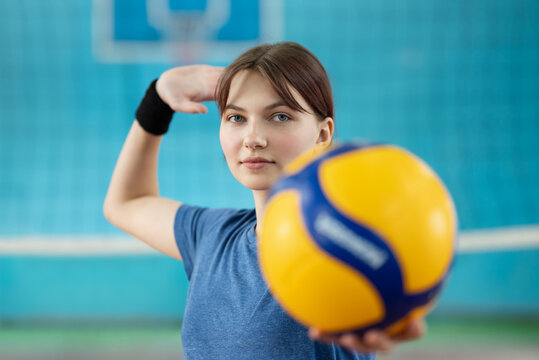 Picture of a young female serving the ball during volleyball practice. Girl having volleyball training on court, main skills for playing a good game