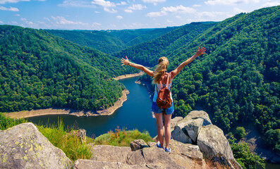 Hiker woman with arms open on cliff enjoying panoramic view- Adventure, travel or sport concept
